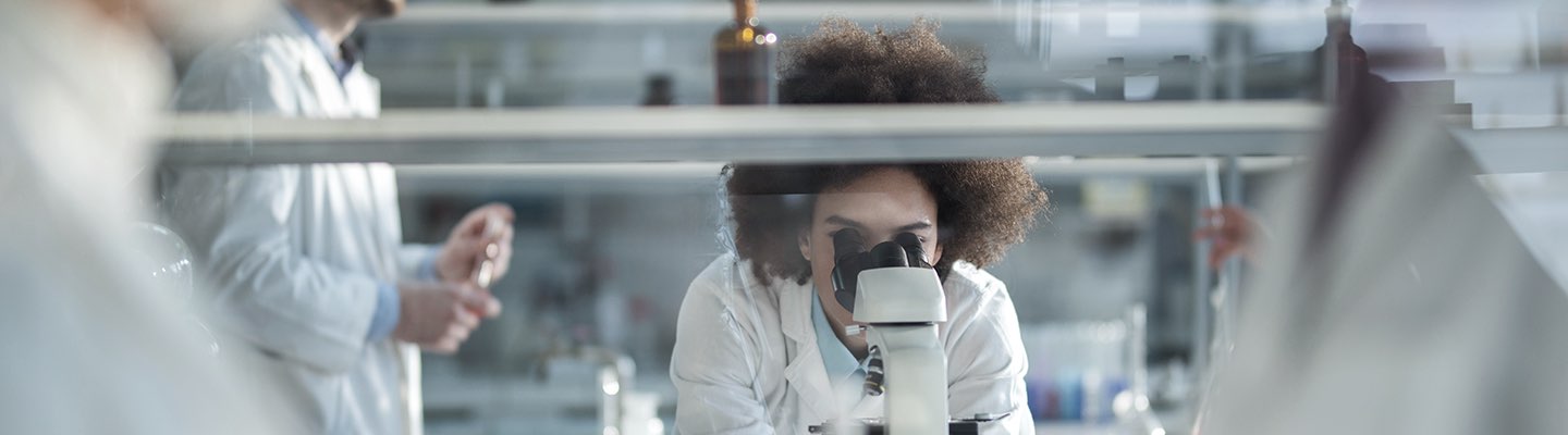 Científico mirando por un microscopio